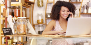 young woman works on laptop computer while running her small business
