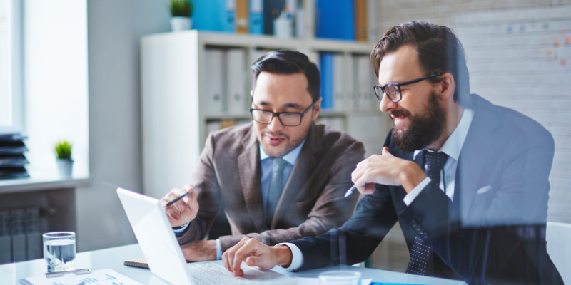 A business owner and account consultant discussing reports.