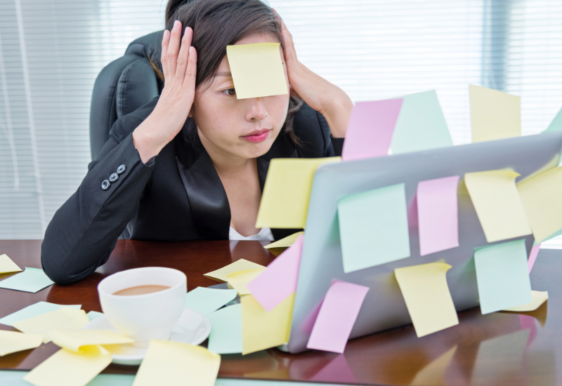 An overwhelmed small business owner covered in sticky notes.